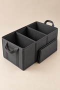 A charcoal fold-flat trunk organizer shown open with divided storage compartments.